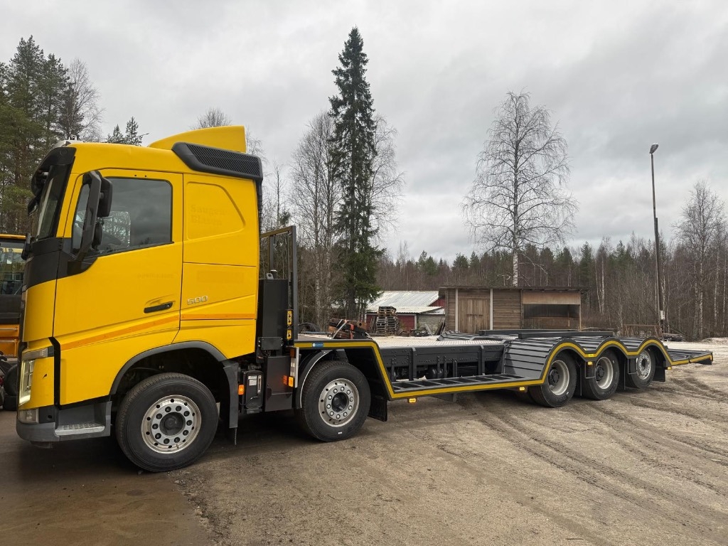 Volvo FH 500 10x4 uudella metsäkoneen kuljetus ritilällä