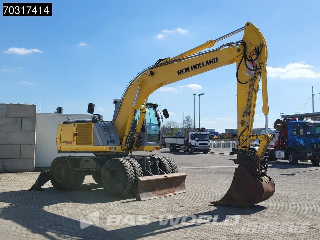 New Holland MH 5.6 Outriggers + Blade Kolesové rýpadlá
